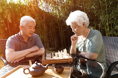 策略桌子象棋老年夫妇在院子里下棋图片