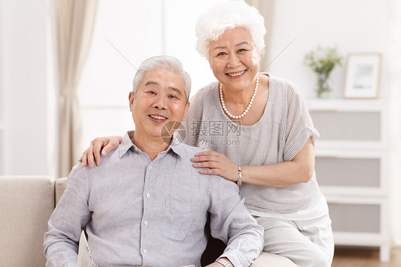 人微笑的永远年轻幸福的老年夫妇在客厅图片