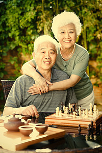 亲情信心相伴老年夫妇在院子里下棋图片