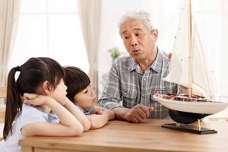 人家庭天真祖父陪孙辈在客厅玩耍图片