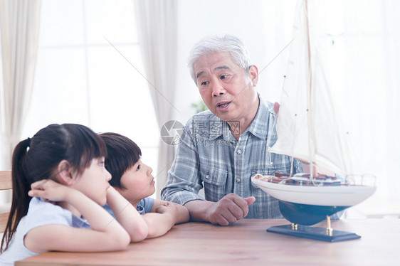 桌子亚洲童年祖父陪孙辈在客厅玩耍图片
