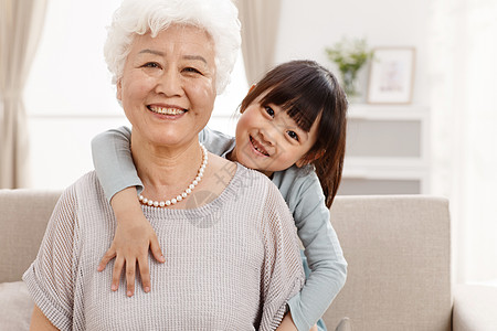 深情的65到69岁天真可爱的小女孩和祖母在客厅图片