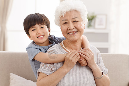 装饰物幸福可爱的小男孩和祖母在客厅图片