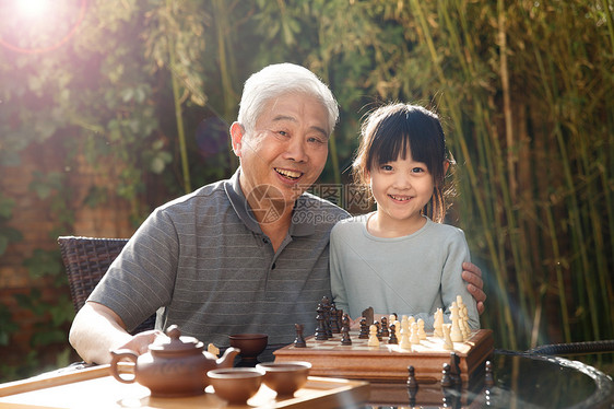 放松满意北京祖父和孙女在庭院里图片