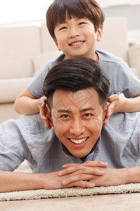 小生活字体两个人趴着彩色图片快乐的父子在客厅玩耍背景