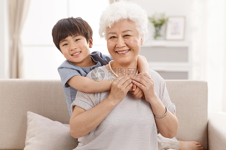 正面视角人休闲追求可爱的小男孩和祖母在客厅图片
