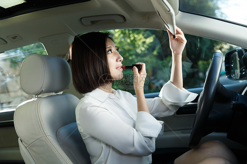 青年女人坐在车里化妆图片