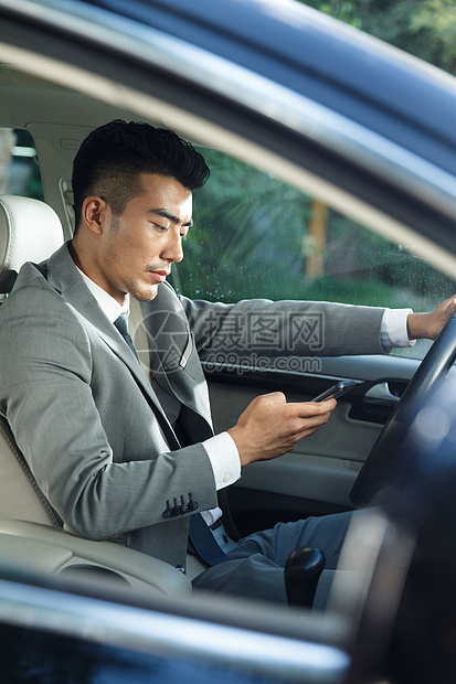 商务青年男人开车看手机图片