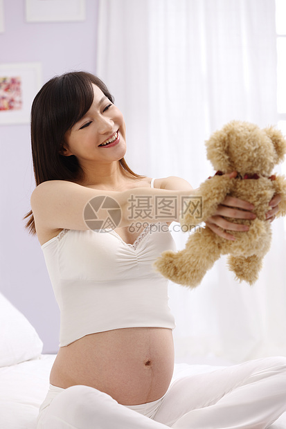 关爱女人轻松孕妇拿着玩具熊图片