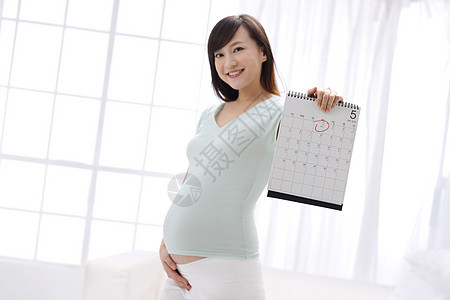 快乐预测幸福孕妇拿着日历牌图片