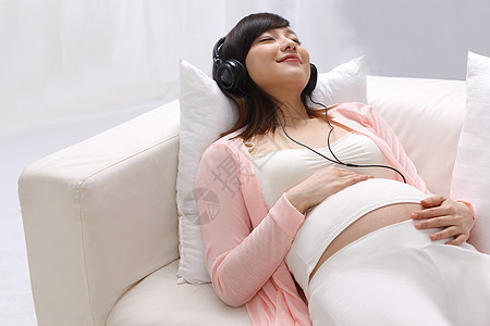 孕妇躺在沙发上听音乐图片
