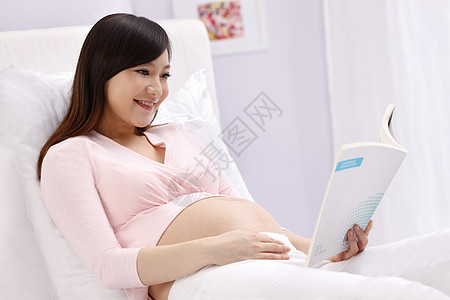 读书倚靠仅女人孕妇坐在床上看书图片