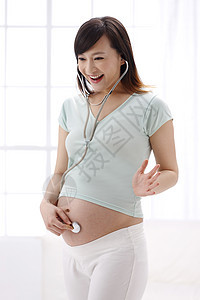 孕育放松侧面视角孕妇戴听诊器图片