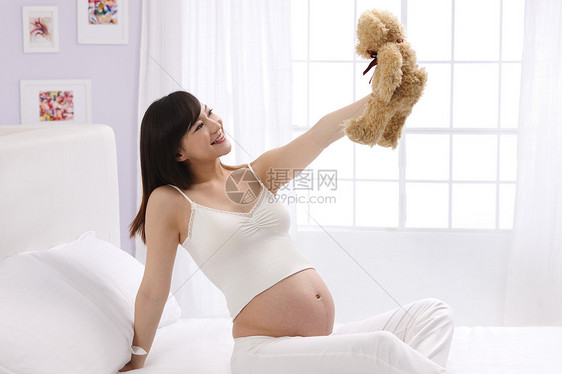 爱住宅房间仅女人孕妇拿着玩具熊图片