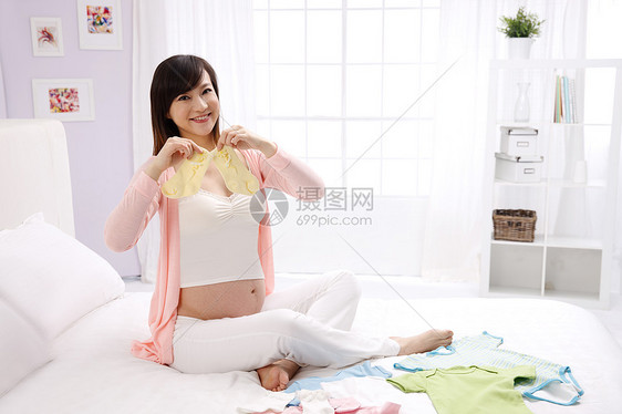 舒适仅女人身体关注孕妇拿着婴儿袜子图片