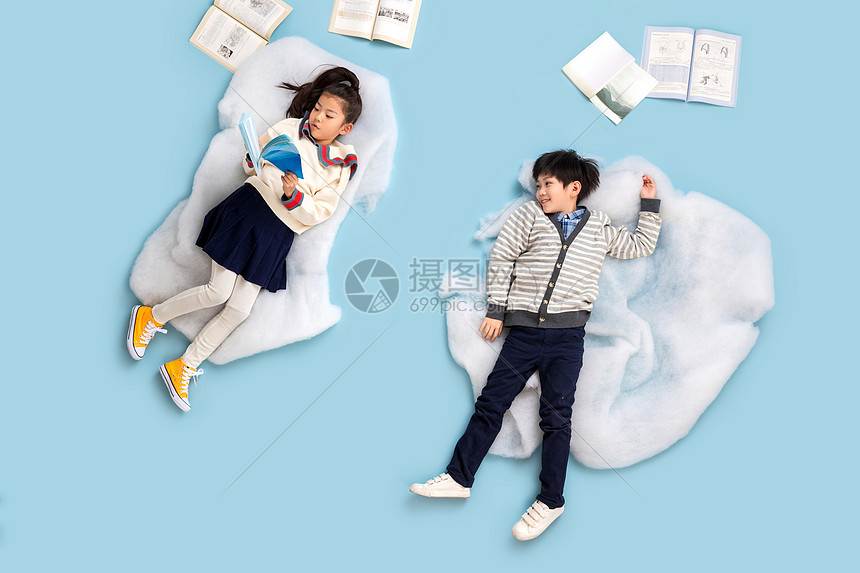 快乐儿童躺在云彩上看书图片