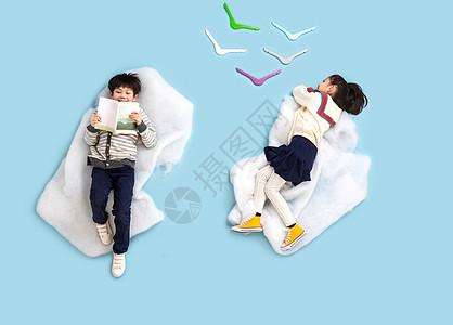 快乐儿童躺在云彩上看书玩耍图片
