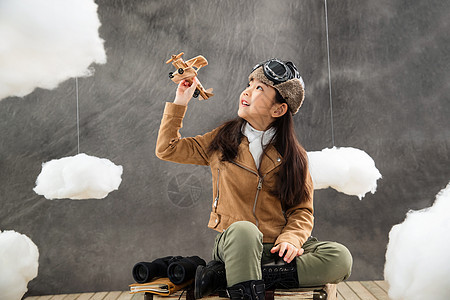 坐在行李箱上的女孩拿着飞机模型图片