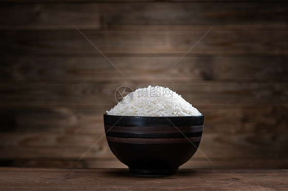 木质桌面上的一碗米饭图片