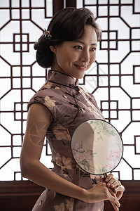 自信穿旗袍拿着扇子的东方女人图片