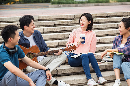 年轻的大学生坐在台阶上闲聊图片