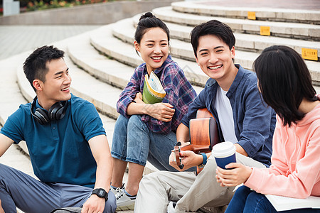 年轻的大学生坐在台阶上闲聊图片