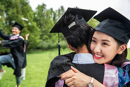 户外穿着学士服的大学生拥抱告别图片