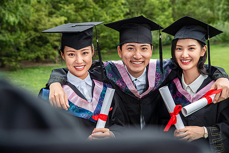 北京蓝天户外三个穿着学士服的大学生搂在一起背景