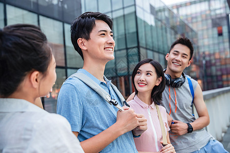 户外四个大学生一起靠在护栏上闲聊图片