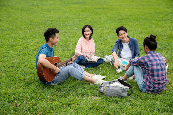 友谊绿色交流快乐的大学生在草地上弹吉他唱歌图片