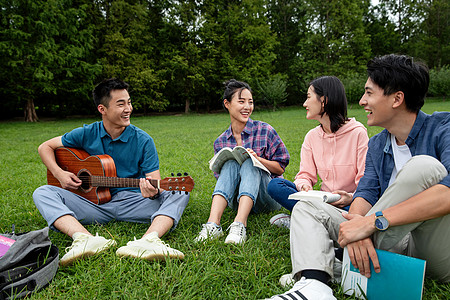 骄傲女朋友成年人快乐的大学生在草地上弹吉他唱歌图片