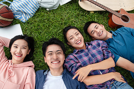 四个人快乐的大学生躺在草地上图片