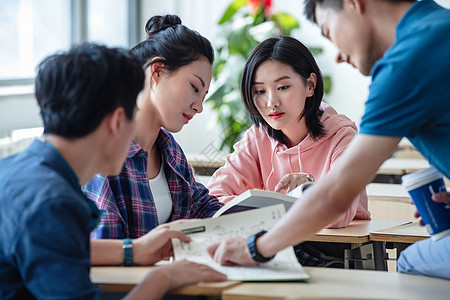 坐着白昼乐趣大学生在教室内交流学习图片