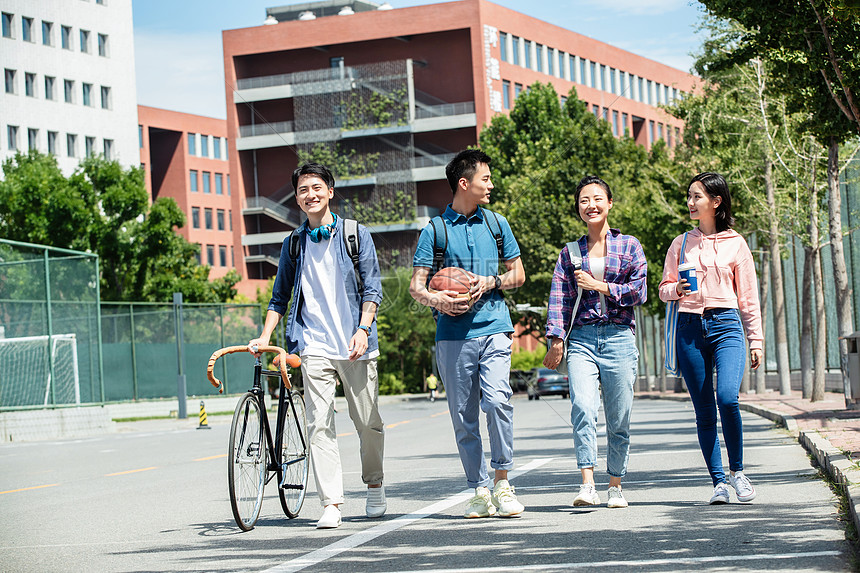 青年文化同学青年伴侣快乐的大学生在校园里步行图片