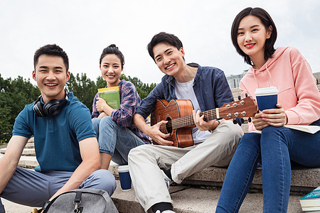 年轻的大学生坐在台阶上弹吉他图片