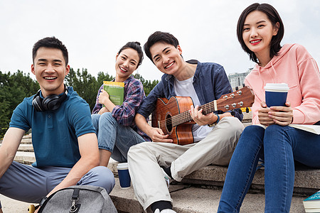 年轻的大学生坐在台阶上弹吉他图片