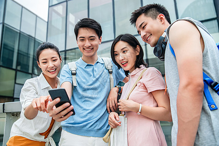 青年一起看手机20到24岁相伴选择对焦户外四个大学生一起看手机背景