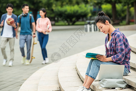 校园里坐在台阶上自学的大学生图片