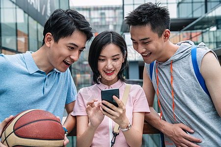 运动篮球休闲快乐的大学生在户外看手机图片