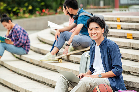 快乐的大学生坐在台阶上学习图片