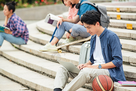 快乐的大学生坐在台阶上学习图片