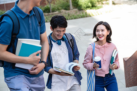 说话讨论教科书下课后的大学生在校园里图片