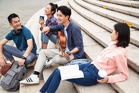 唱歌弹奏亚洲年轻的大学生坐在台阶上弹吉他图片
