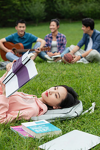 满意智慧坐着大学生在草地上享受课余时间图片