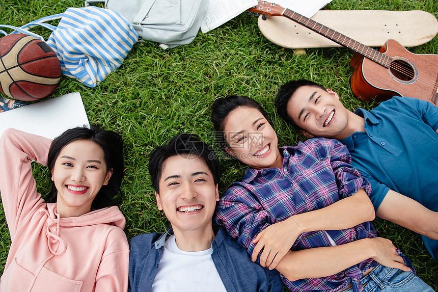 业余爱好表现积极户外快乐的大学生躺在草地上