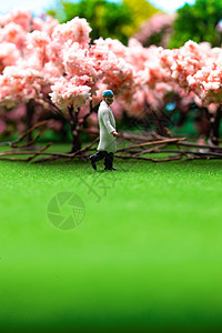 防疫樱花树下草地上医生行走的身影图片