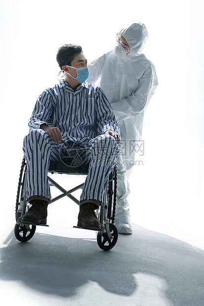 医务工作者推着坐轮椅的患者图片