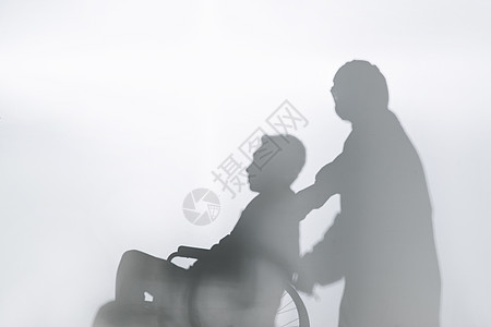 医务工作者推着坐轮椅的患者剪影图片