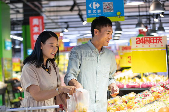 中年夫妇在超市挑选水果图片