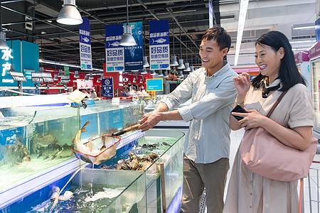 城市生活中年夫妇在超市买鱼图片
